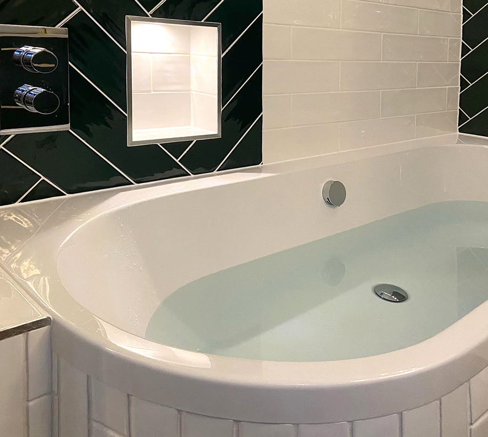 Half filled bath tub with stylish tiling