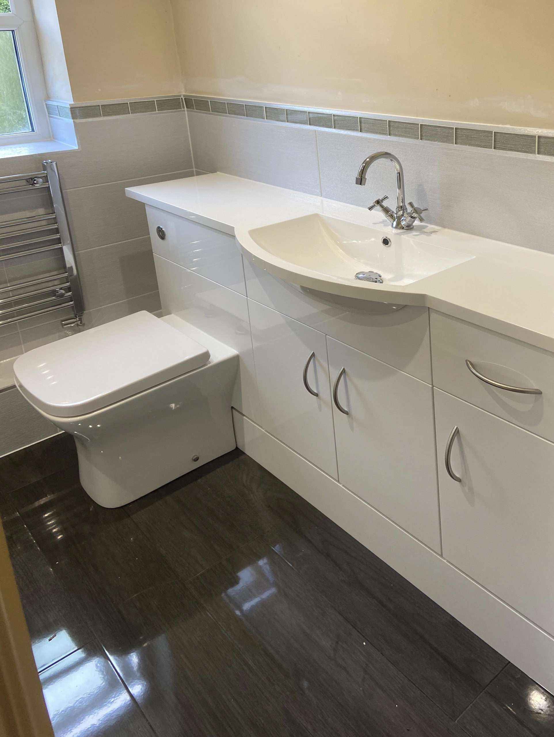 white sink with cupboards with toilet built in